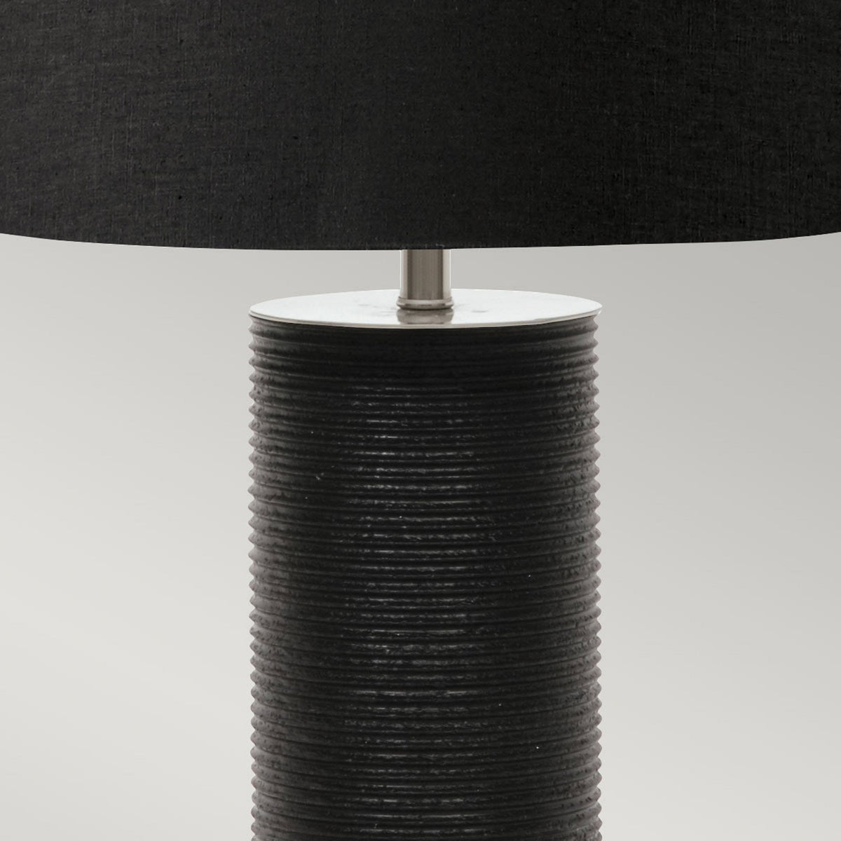 Black lamp with a textured cylindrical base and a smooth black fabric shade