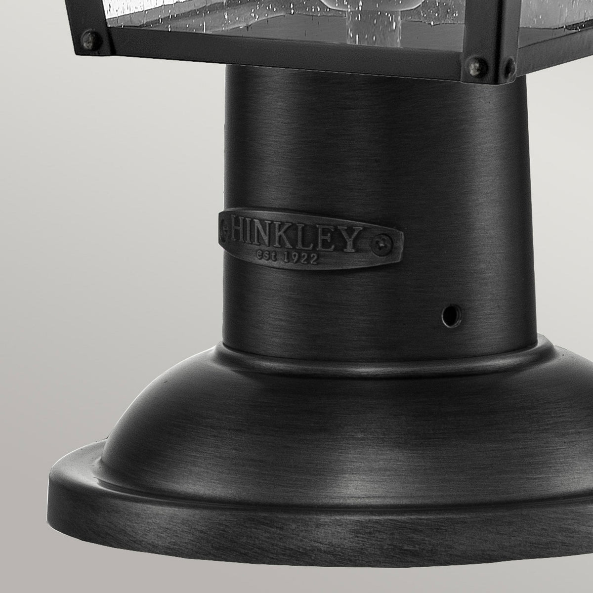 A close-up of the base of an outdoor post light, showing the Hinkley logo.