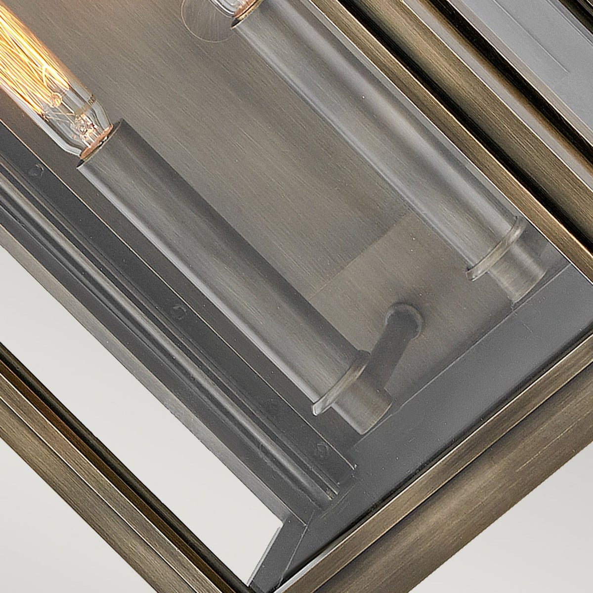 A detailed view of the brass framework and bulb holder within an outdoor lantern.