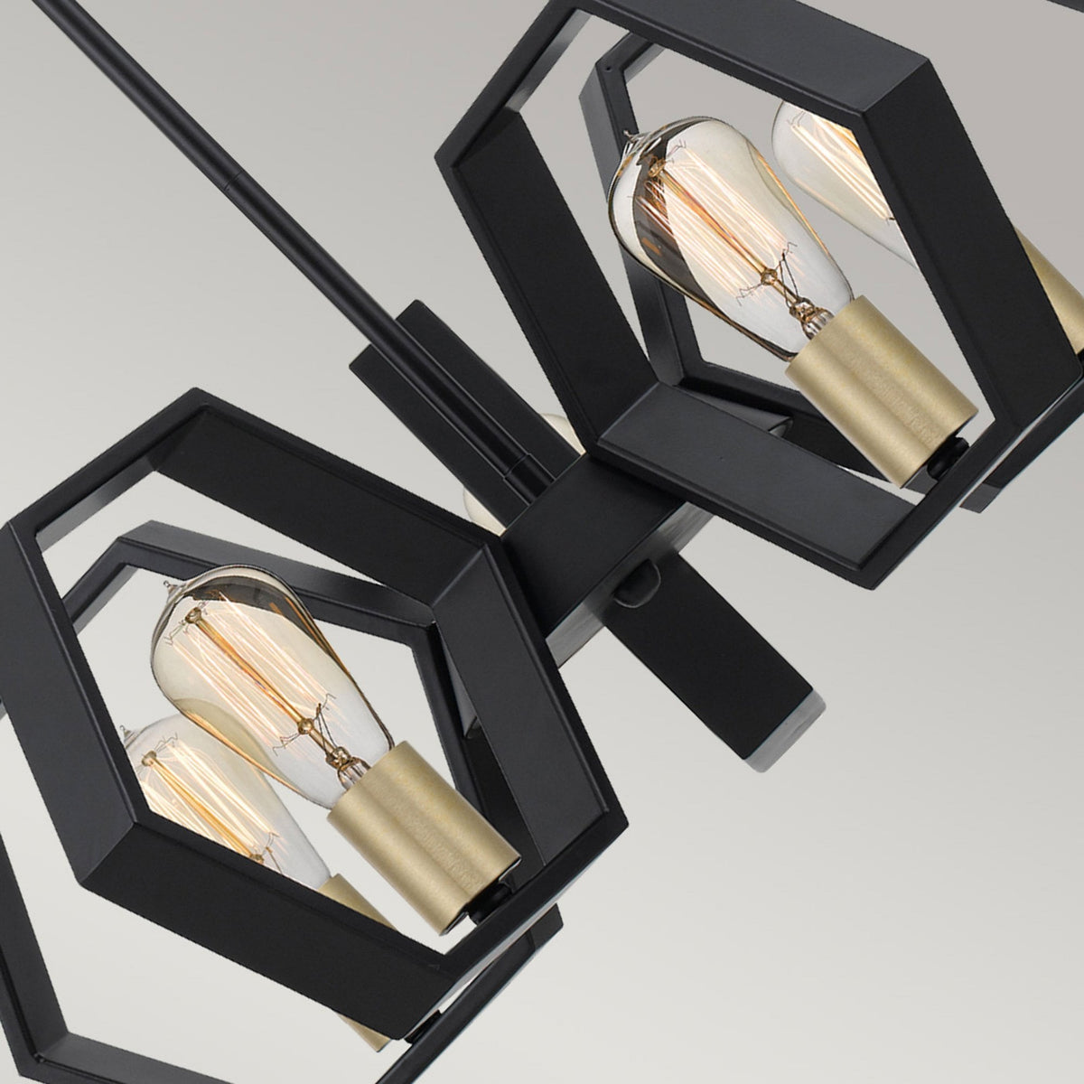 Close-up of the black hexagonal frames and exposed bulbs of the multi-light pendant.