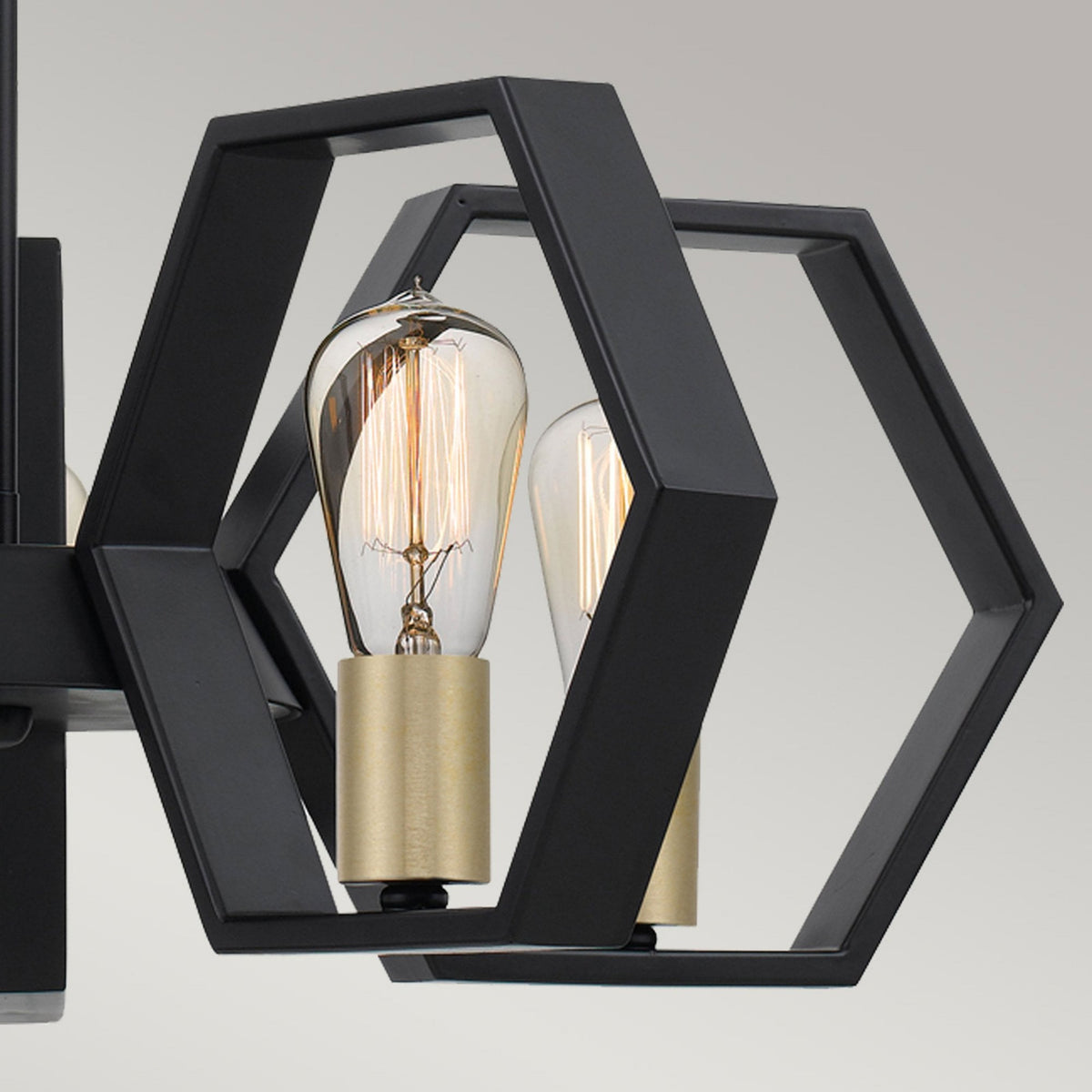Detail of one hexagonal frame with an exposed bulb from the multi-light pendant.