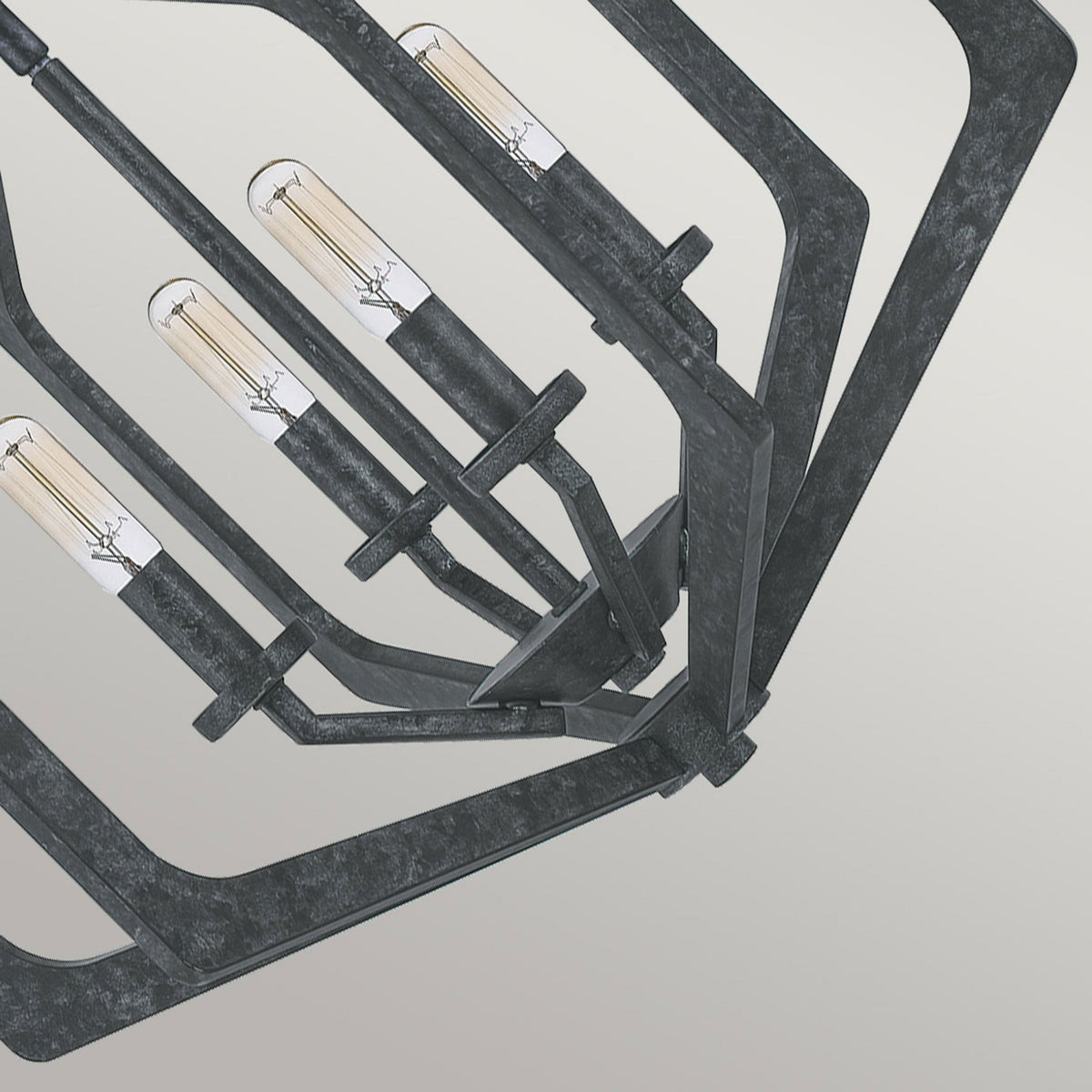 Close-up of the geometric frame and four exposed filament bulbs of the pendant light.