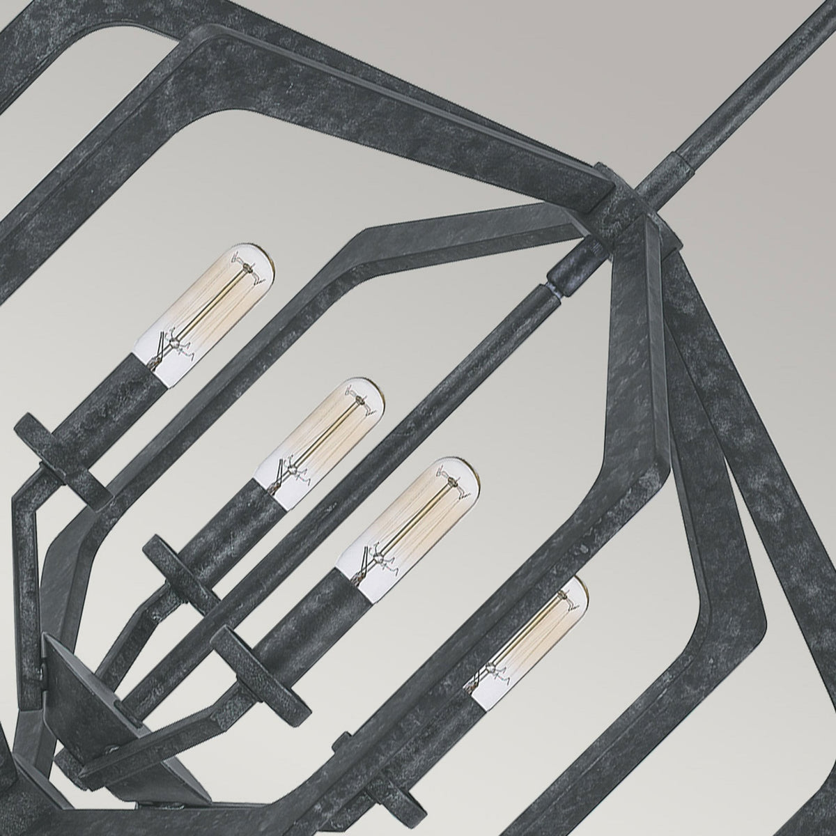 Close-up of the dark, textured geometric frame and exposed bulbs of the pendant light.