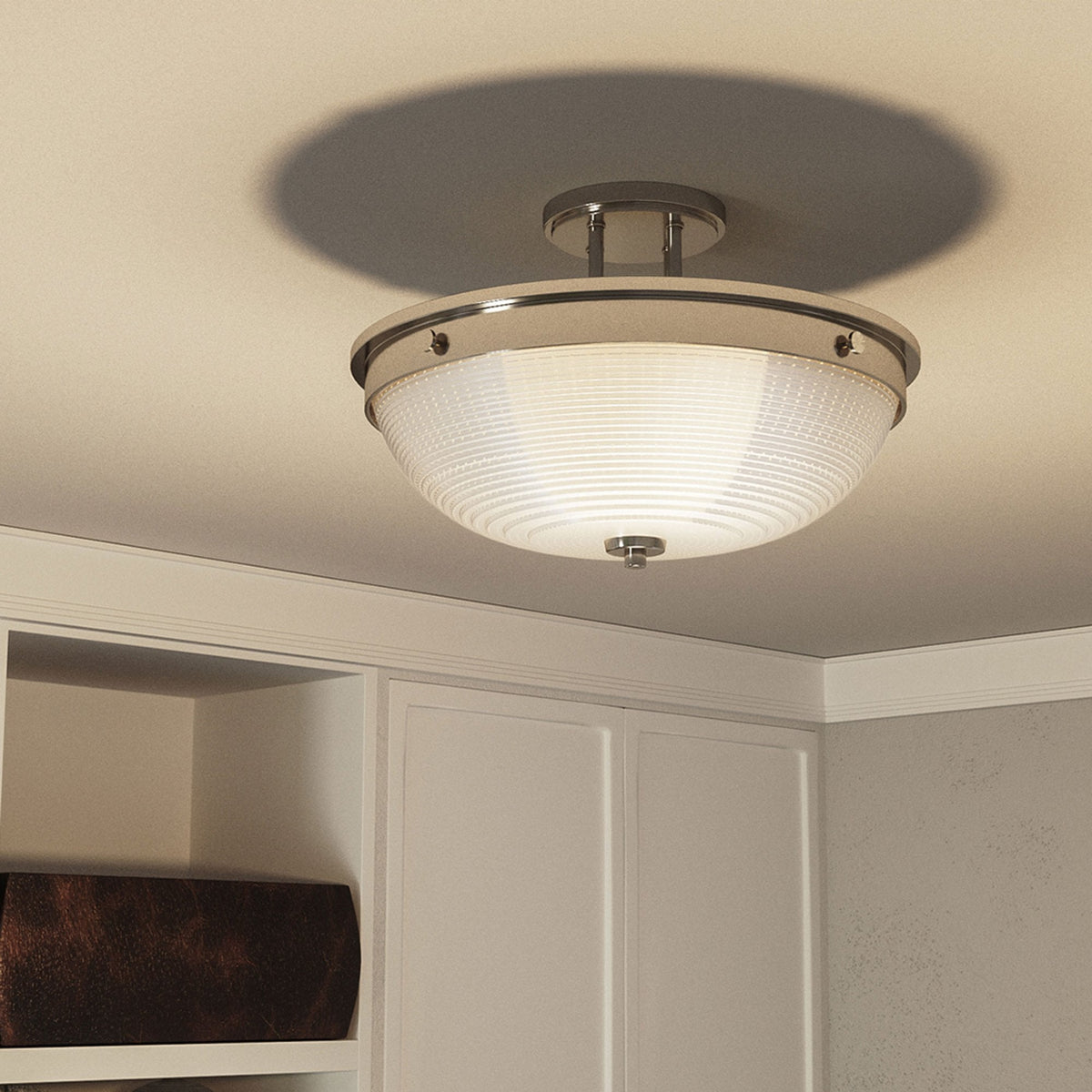 The ceiling light in a room, casting a warm glow and shadow on the ceiling.