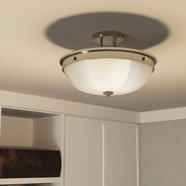 The ceiling light in a room, casting a warm glow and shadow on the ceiling.