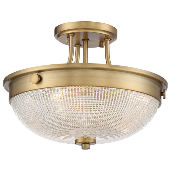 A close-up of a semi-flush ceiling light with an antique brass finish and a clear seeded glass bowl.