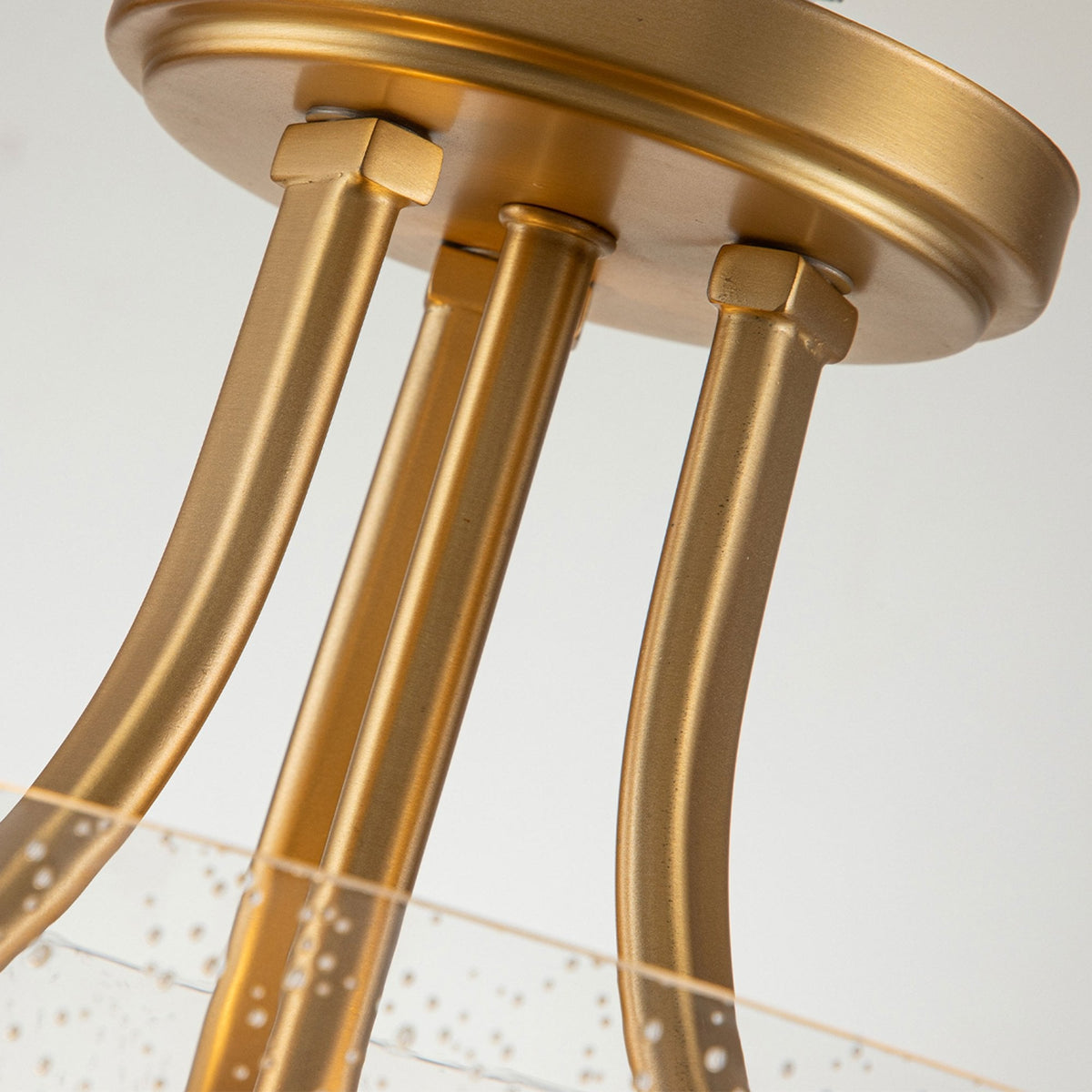 A close-up of the brass frame of a semi-flush ceiling light, showing the mounting detail.