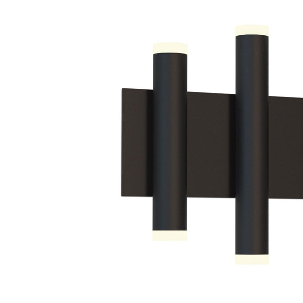 Close-up of a black wall light with two vertical cylindrical lights, emitting light from both ends.