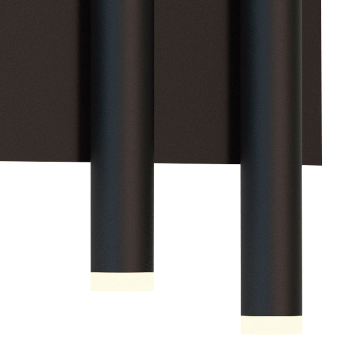 Close-up of the bottom of two black cylindrical wall lights, emitting light downwards.