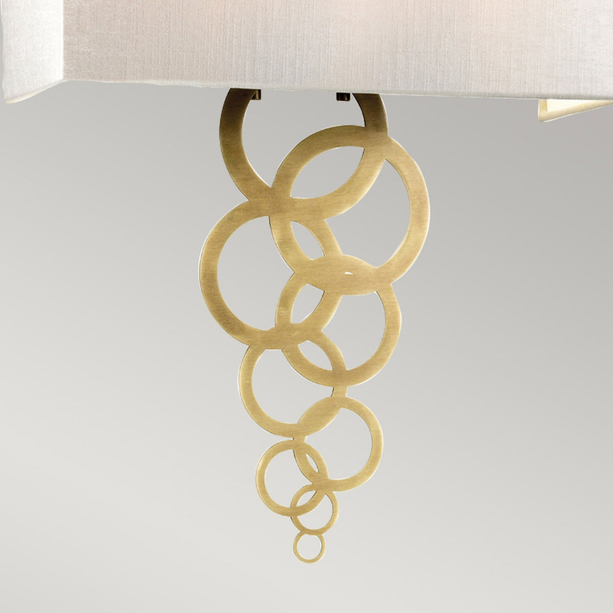 Close-up of the gold-coloured interlocking rings of a modern wall light.