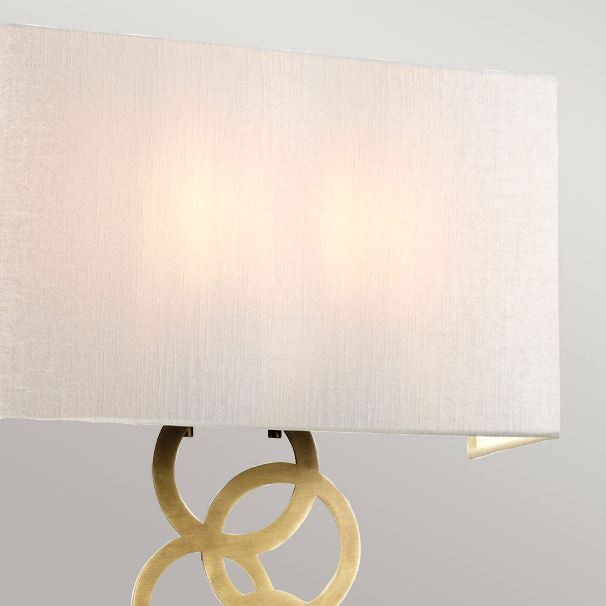 Close-up of the rectangular white shade of a modern wall light, illuminated.