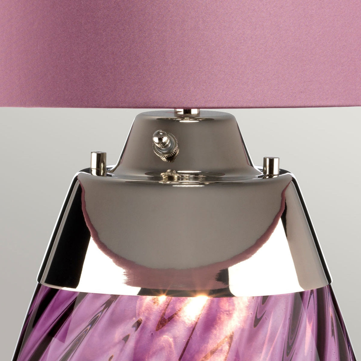 Close-up of the lamp's silver base, with the amethyst glass base visible below.
