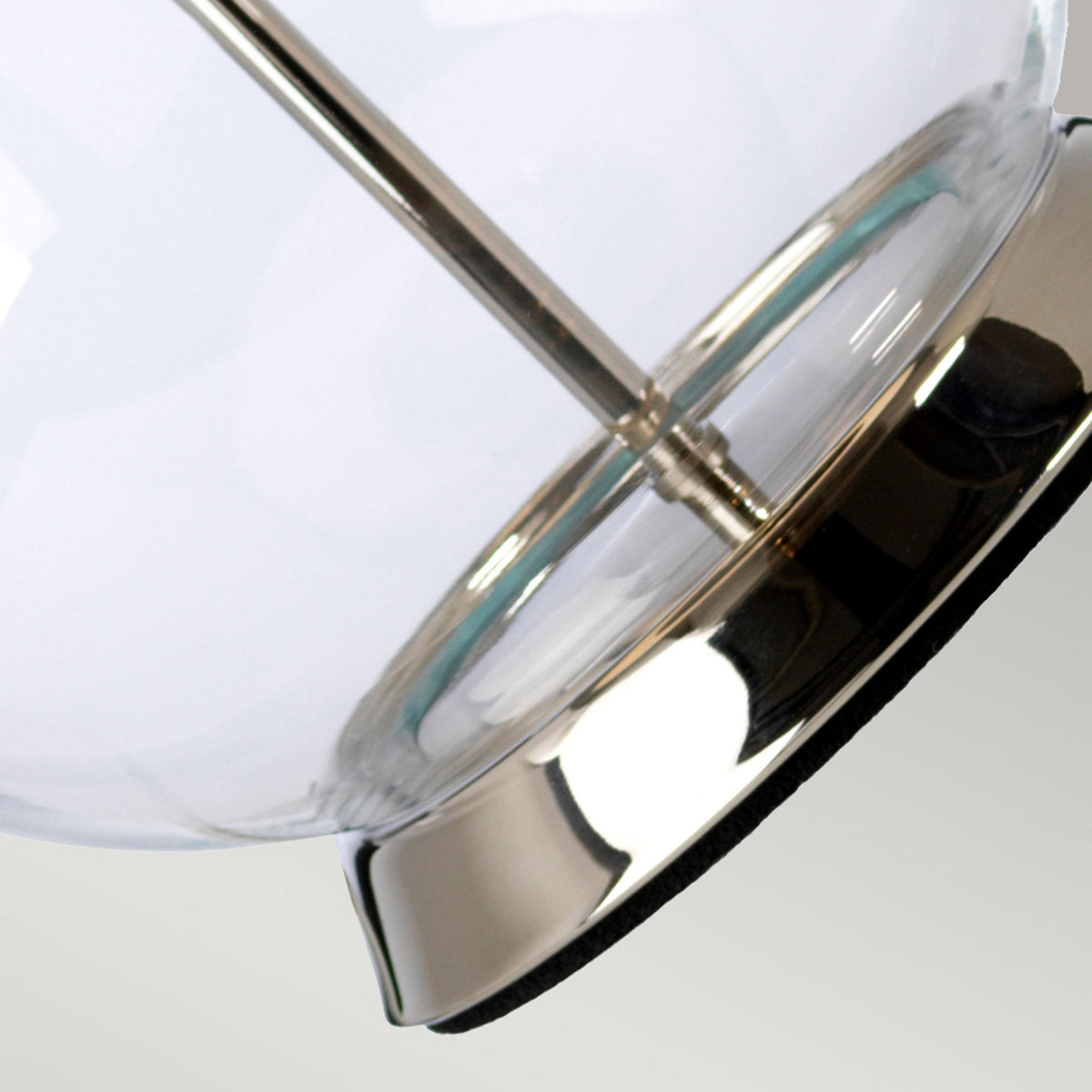 Close up of the shiny silver base of a clear glass table lamp.