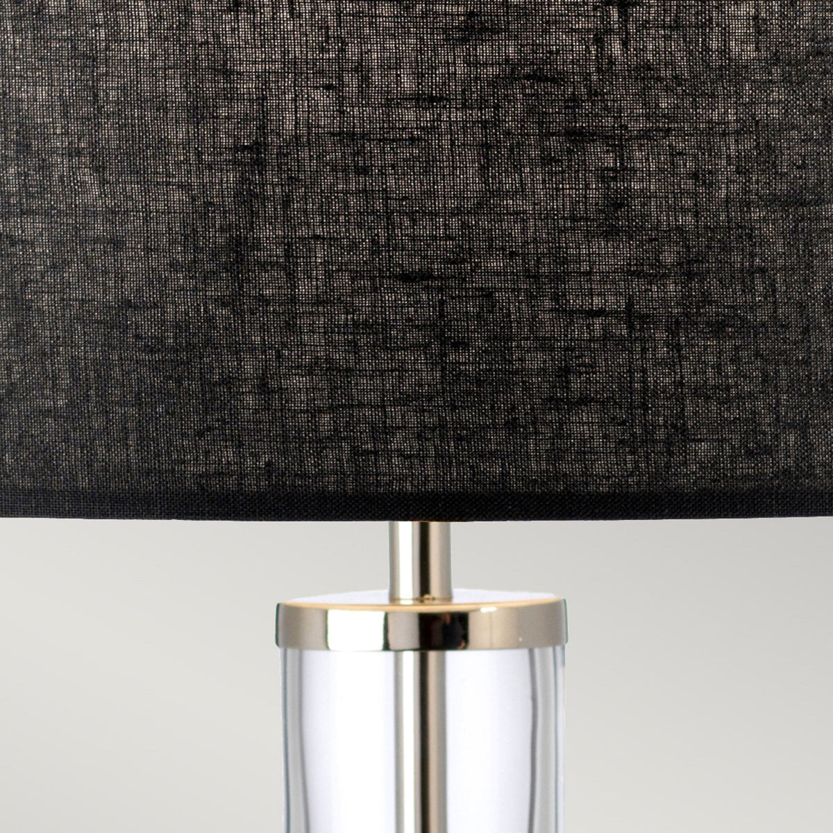 Close up of the base of the dark grey lampshade and top of the lamp stand.