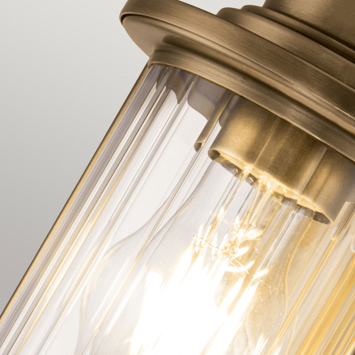 An upward angle of the bronze nautical wall light, showcasing the ribbed glass. 