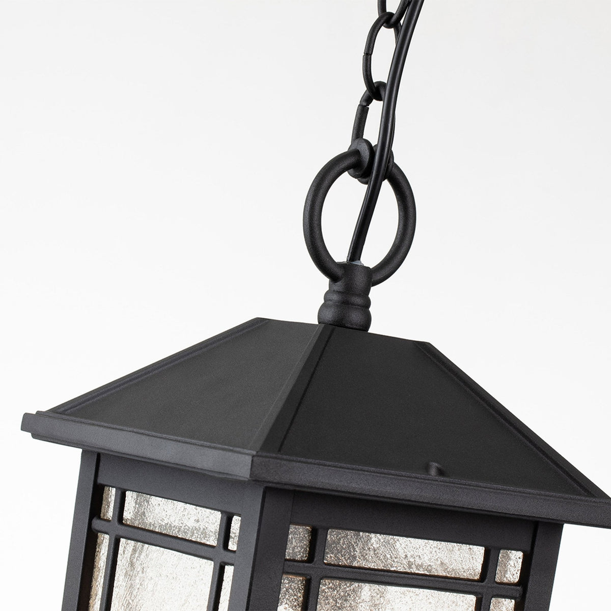 A close-up of the top of the black outdoor pendant light, showing the chain and ring.