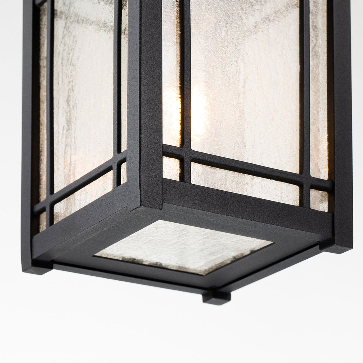 A close-up of the bottom of the black outdoor pendant light, showing the frosted glass.
