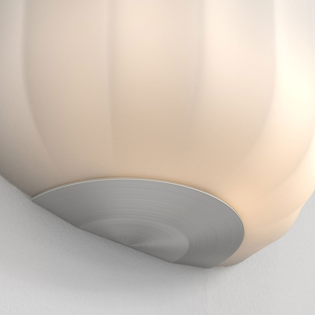 Close-up of a cream-colored ceiling light fixture with a brushed metal base