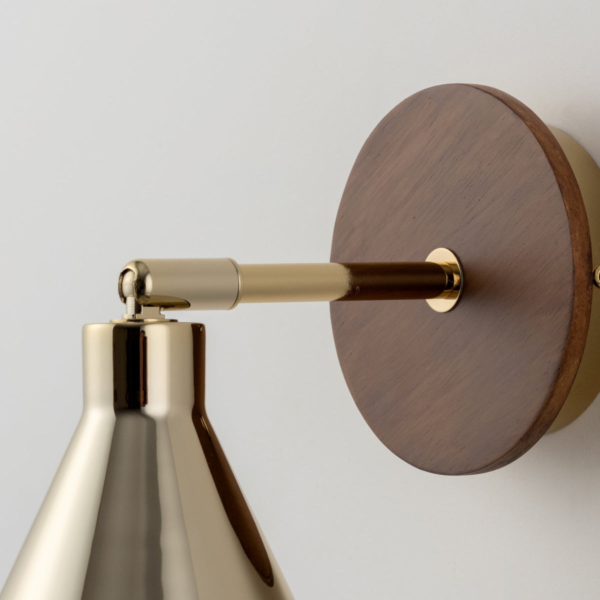 Close-up of the brass and wood detailing on a modern wall lamp.