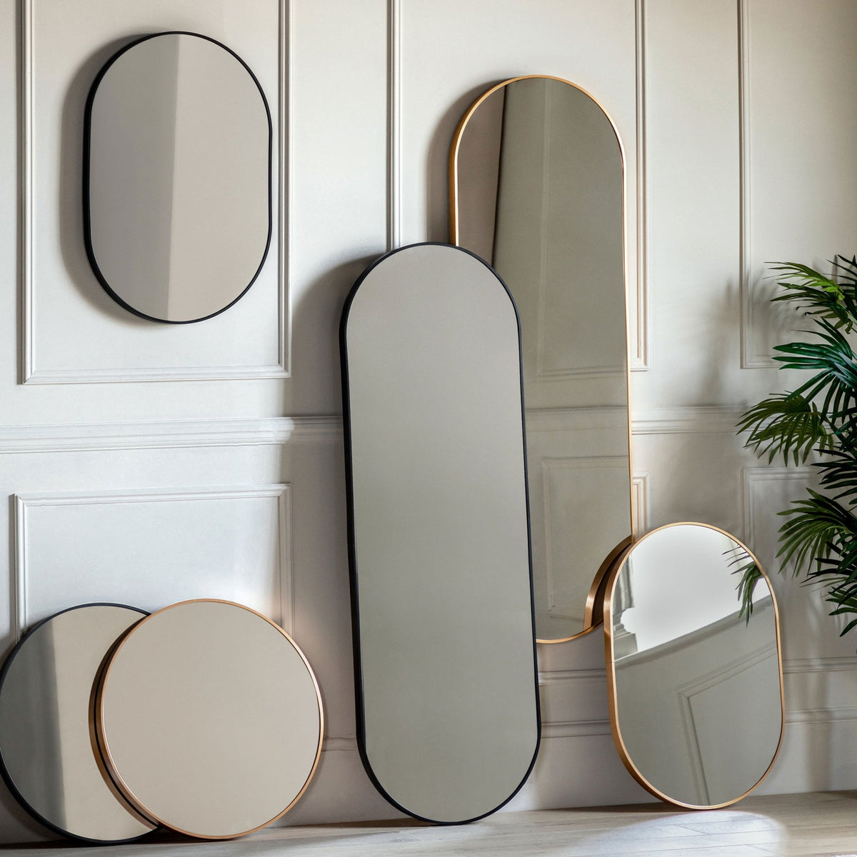 A collection of various mirrors with gold and black frames in different shapes and sizes.