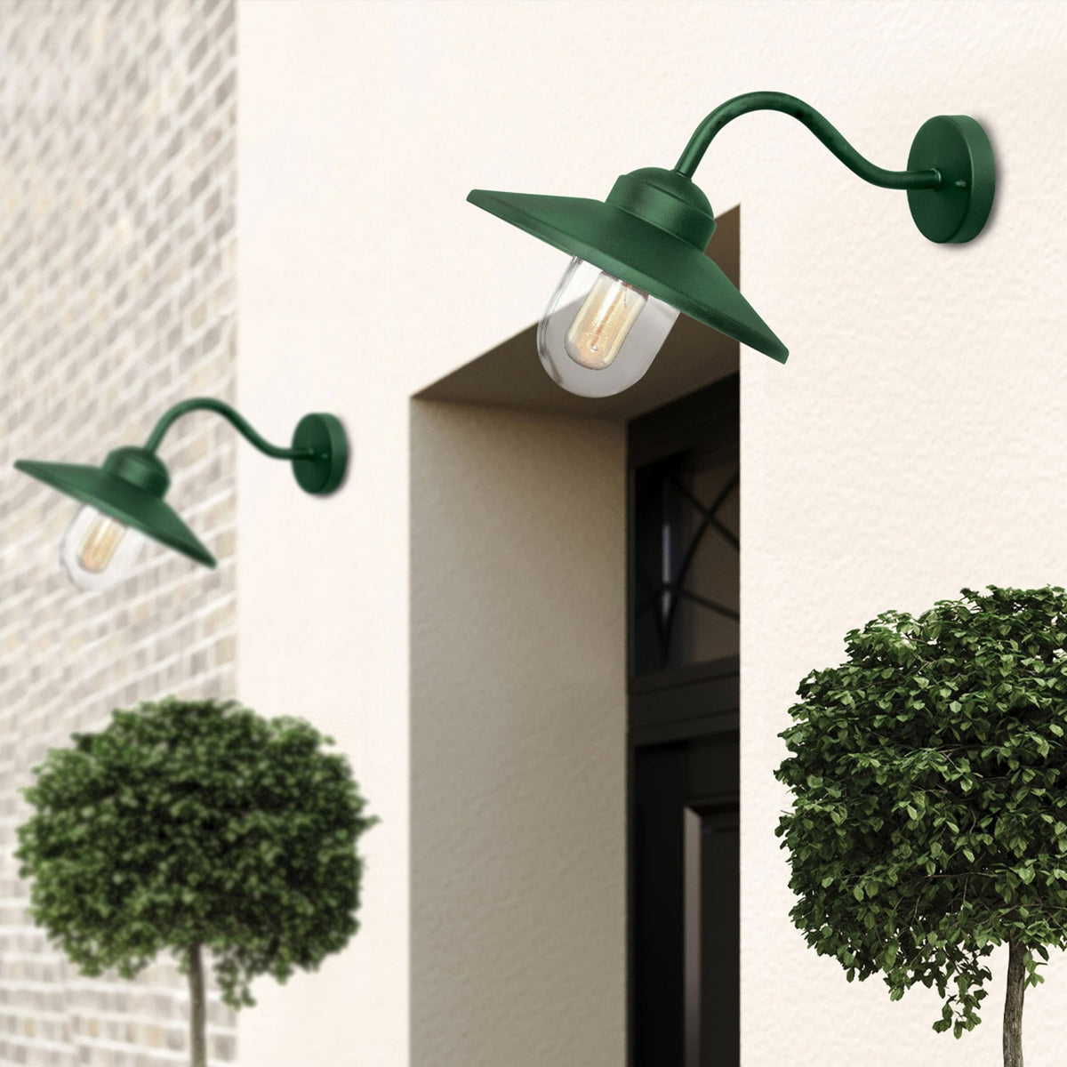 Two dark green barn lights illuminate an outdoor wall, creating a warm ambiance.