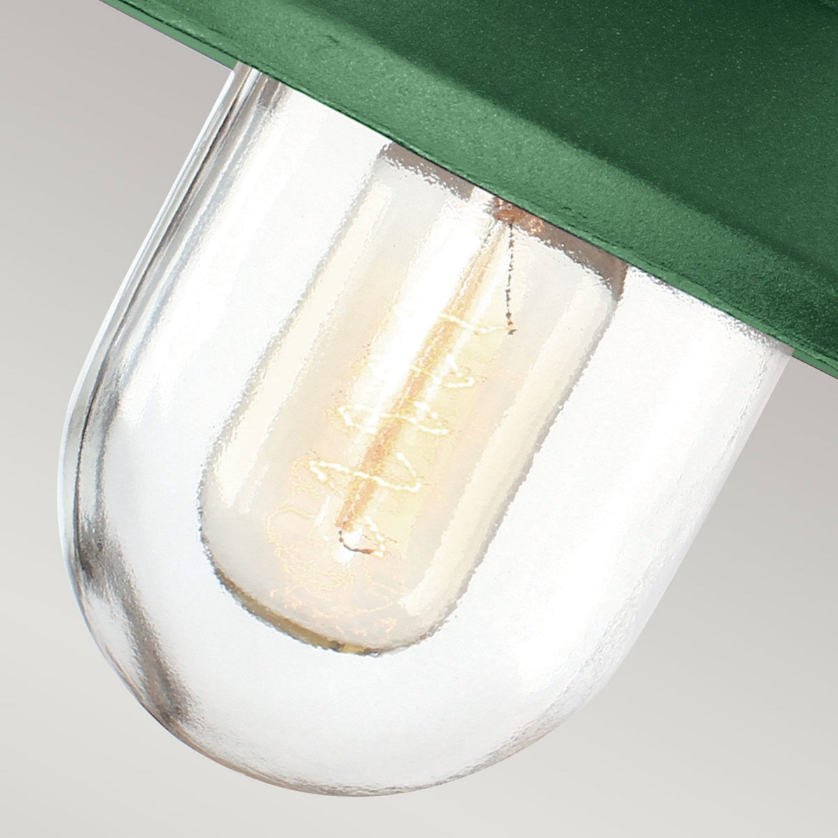 Detailed view of the clear glass shade and vintage-style filament bulb in a barn light.