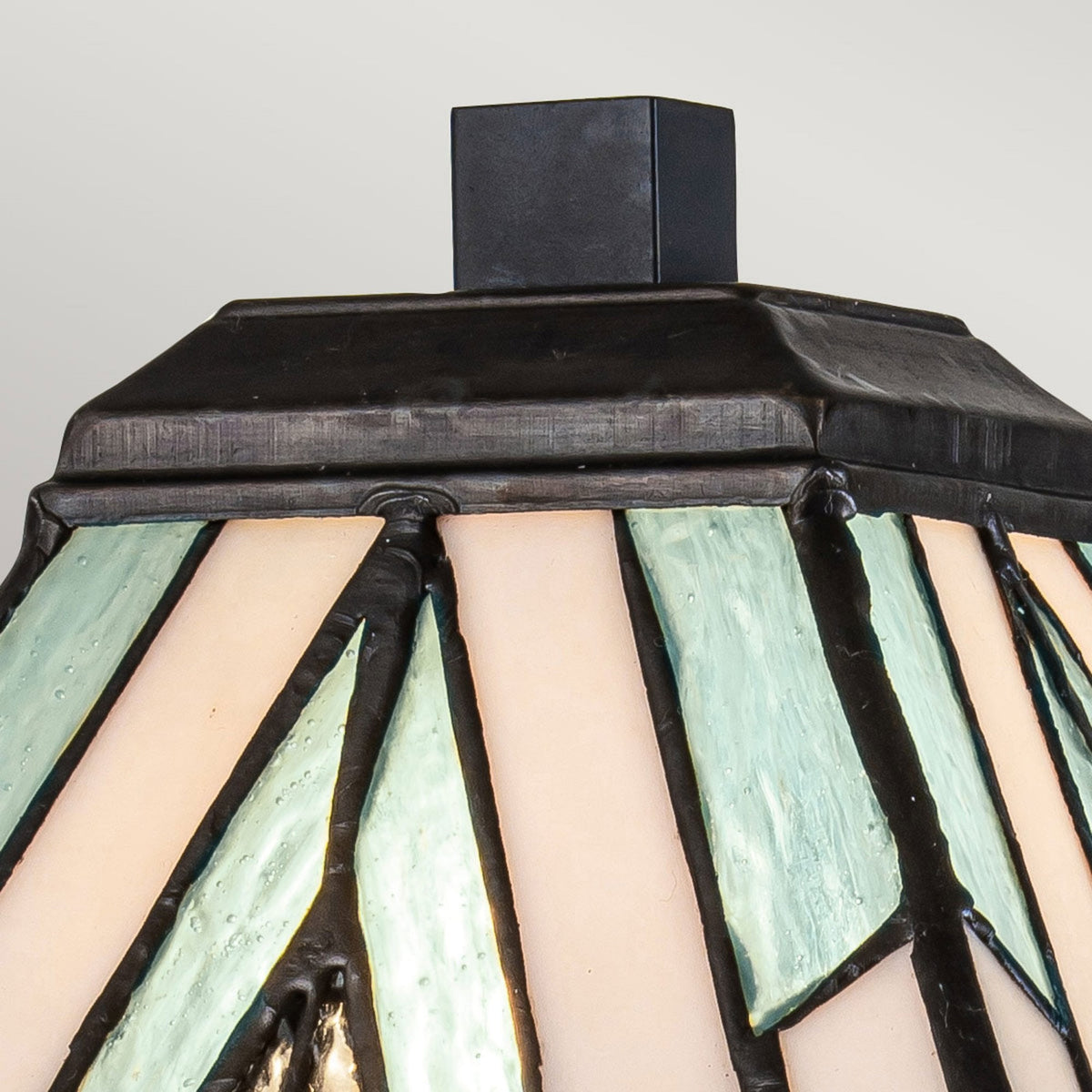 Close-up of the lamp's top, showing the stained glass details and dark metal trim.