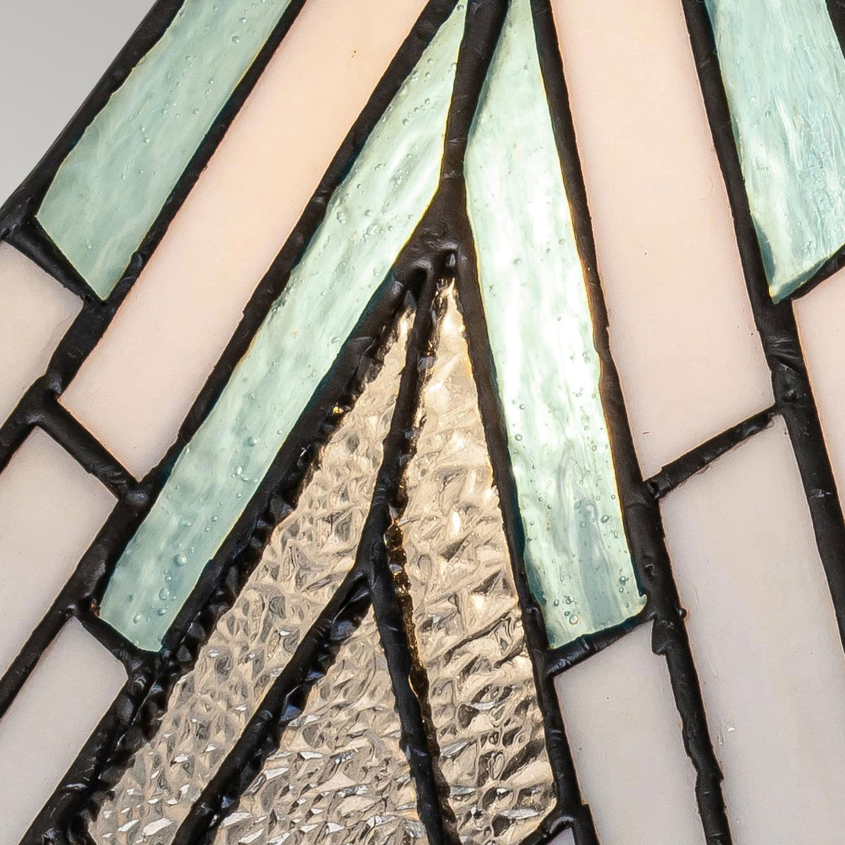 Close-up of the lamp's stained glass shade, showing a mix of blue, white, and clear.