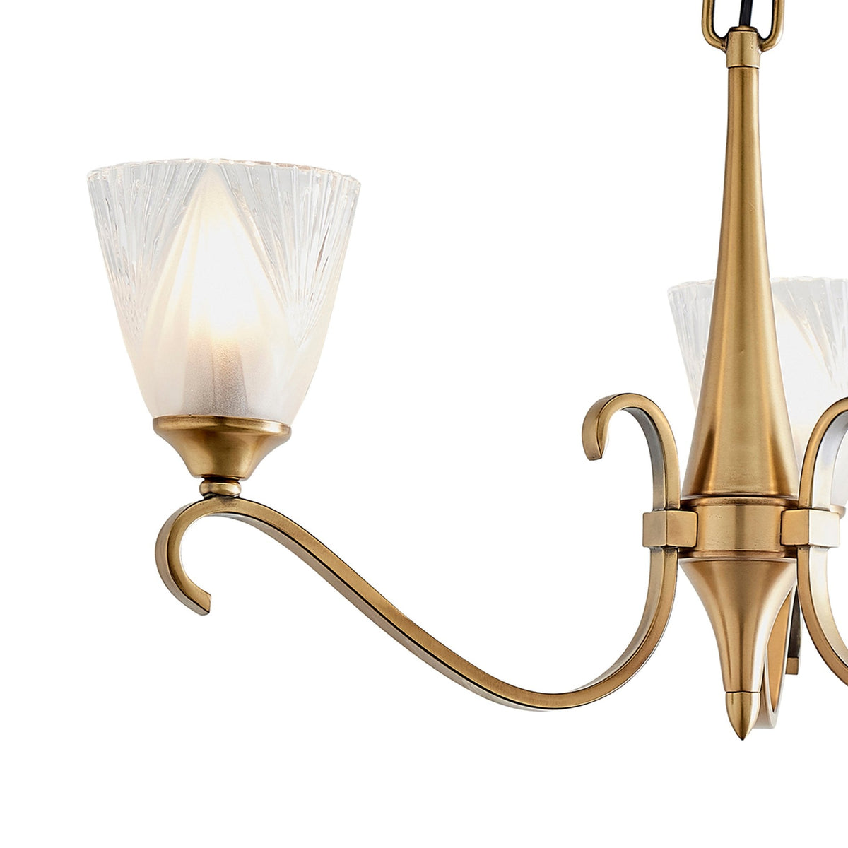 Detailed view of one arm and frosted, fluted glass shade of a brass chandelier.