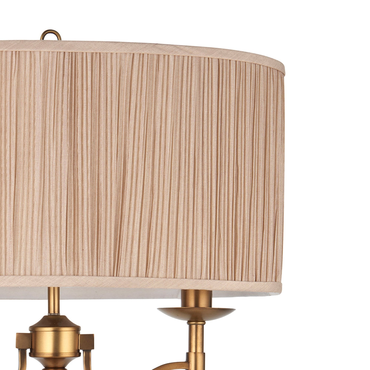 Detail of the finely pleated fabric lampshade and brass fixtures on a table lamp.