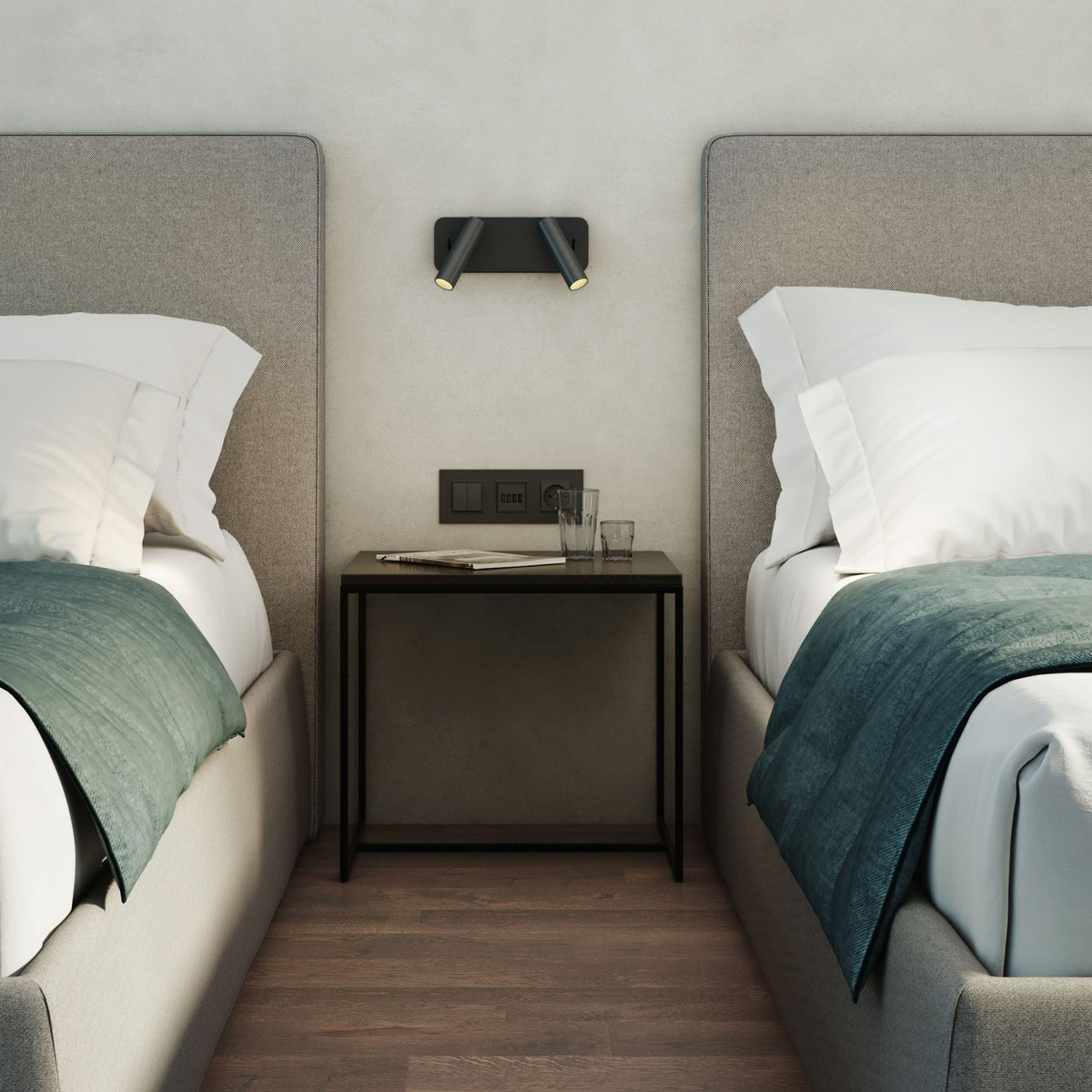 Two beds with white pillows and teal blankets, a nightstand with glasses, and a wall-mounted light