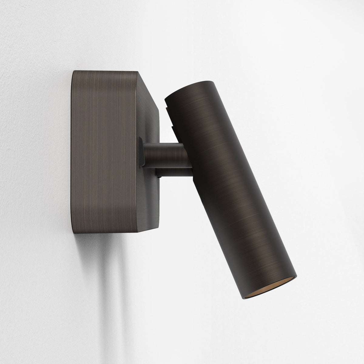 Bronze wall-mounted spotlight with a cylindrical head angled downwards