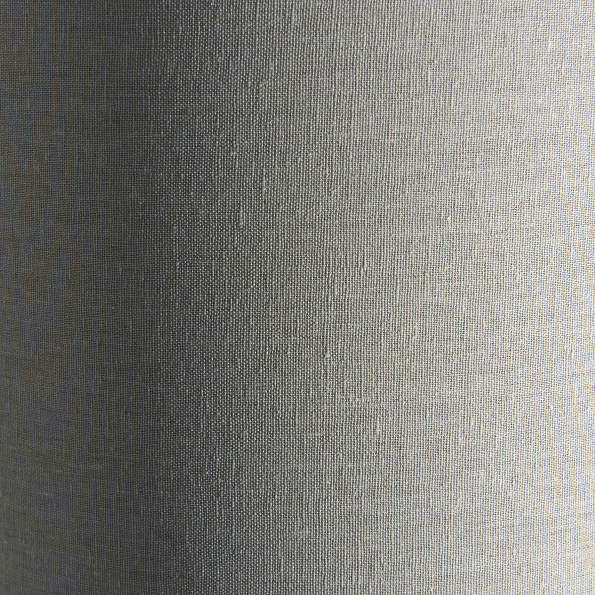 Close-up of the textured fabric of a light gray cylindrical lamp shade.