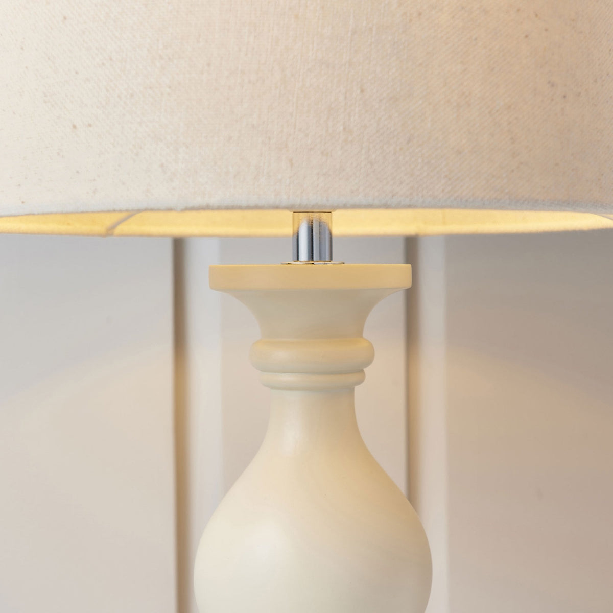 Close-up of the cream table lamp's base and linen shade.
