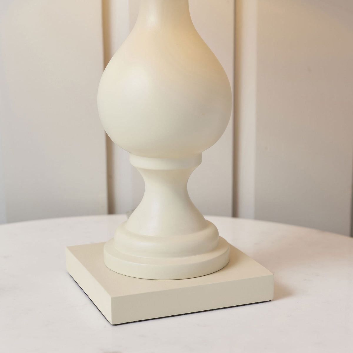 Close-up of the cream table lamp's ornate base.