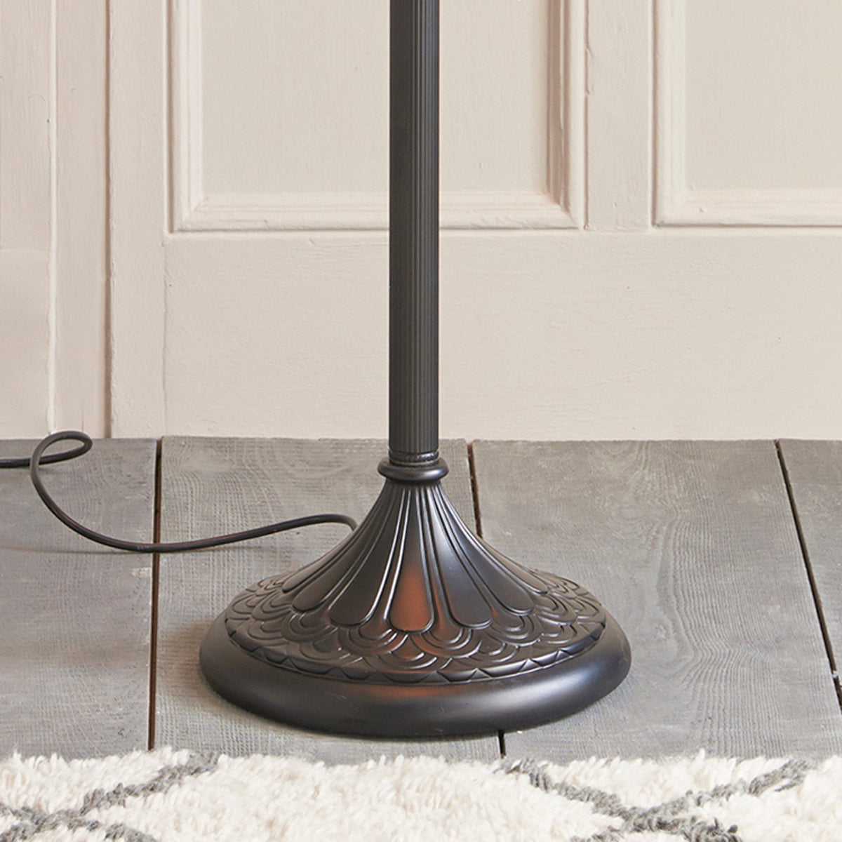 The base of the Tiffany floor lamp with a dark bronze finish and decorative detailing.