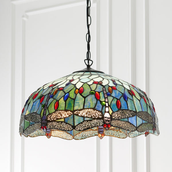 A close up of a Tiffany style stained glass pendant light with a dragonfly motif.