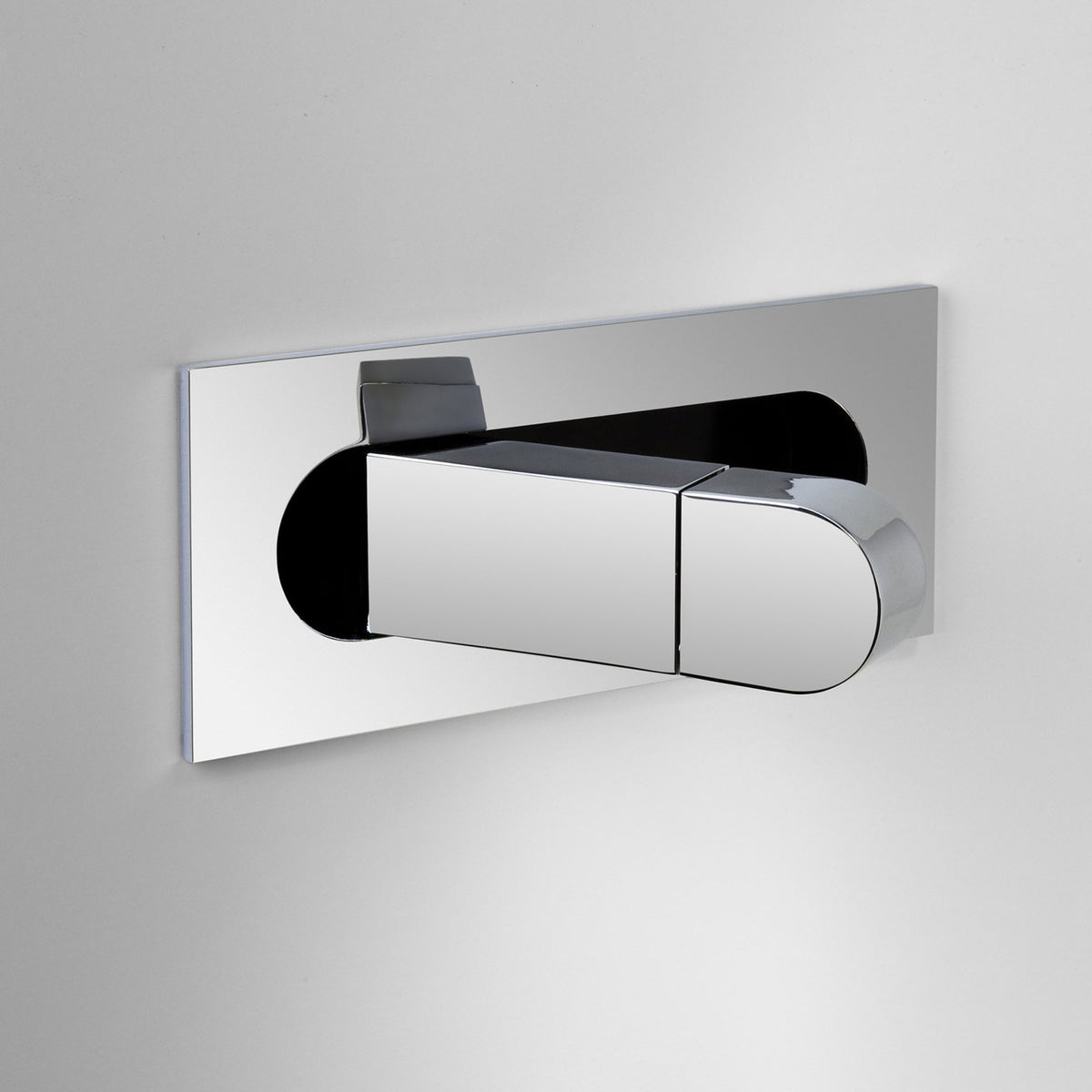 Chrome flush plate with two rectangular buttons, one larger than the other, set against a white wall