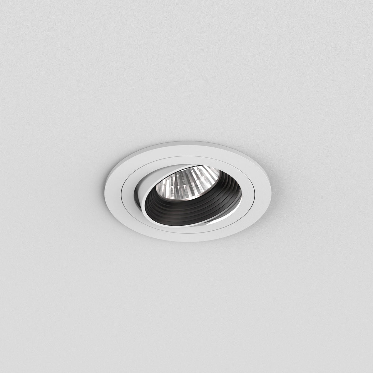 White recessed ceiling light with a black inner ring and a visible bulb, angled downwards