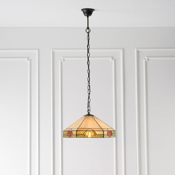 A Tiffany style ceiling pendant light with a stained glass shade, against a white wall.