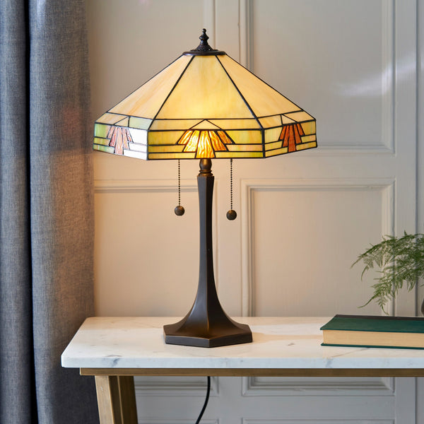 A Tiffany lamp on a marble side table, illuminating a cosy room.