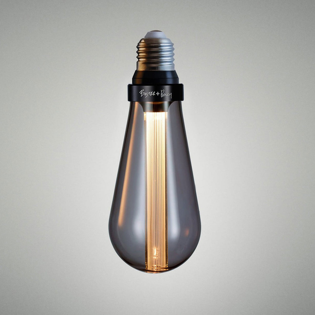 A teardrop-shaped light bulb with a dark glass casing and a glowing filament inside.
