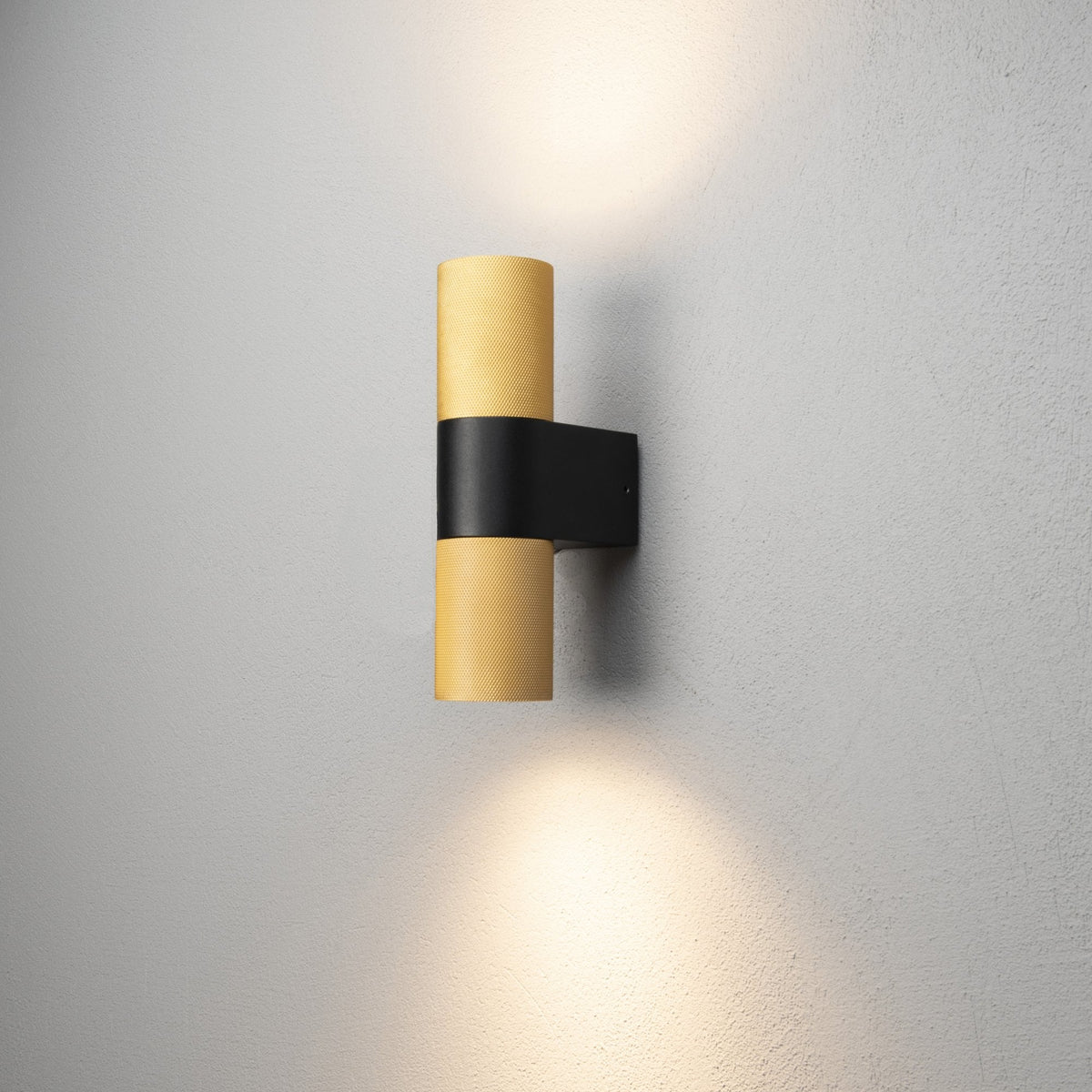 An illuminated outdoor wall light, featuring two light sources, shining up and down.