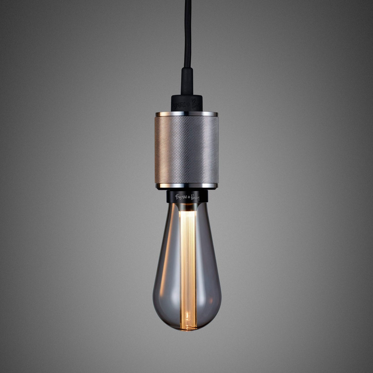 A modern pendant light with a textured silver fixture and a smoked glass bulb with visible filaments.