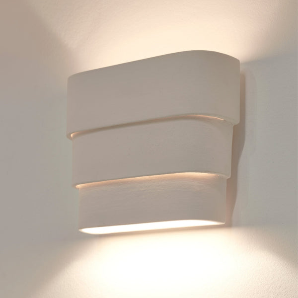 A modern, rectangular wall light with three horizontal layers, casting light upwards and downwards.