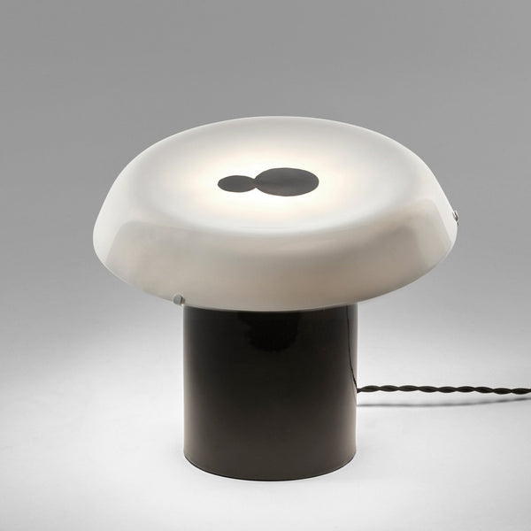 A sleek, modern mushroom-shaped lamp with a dark base and a glowing white shade.