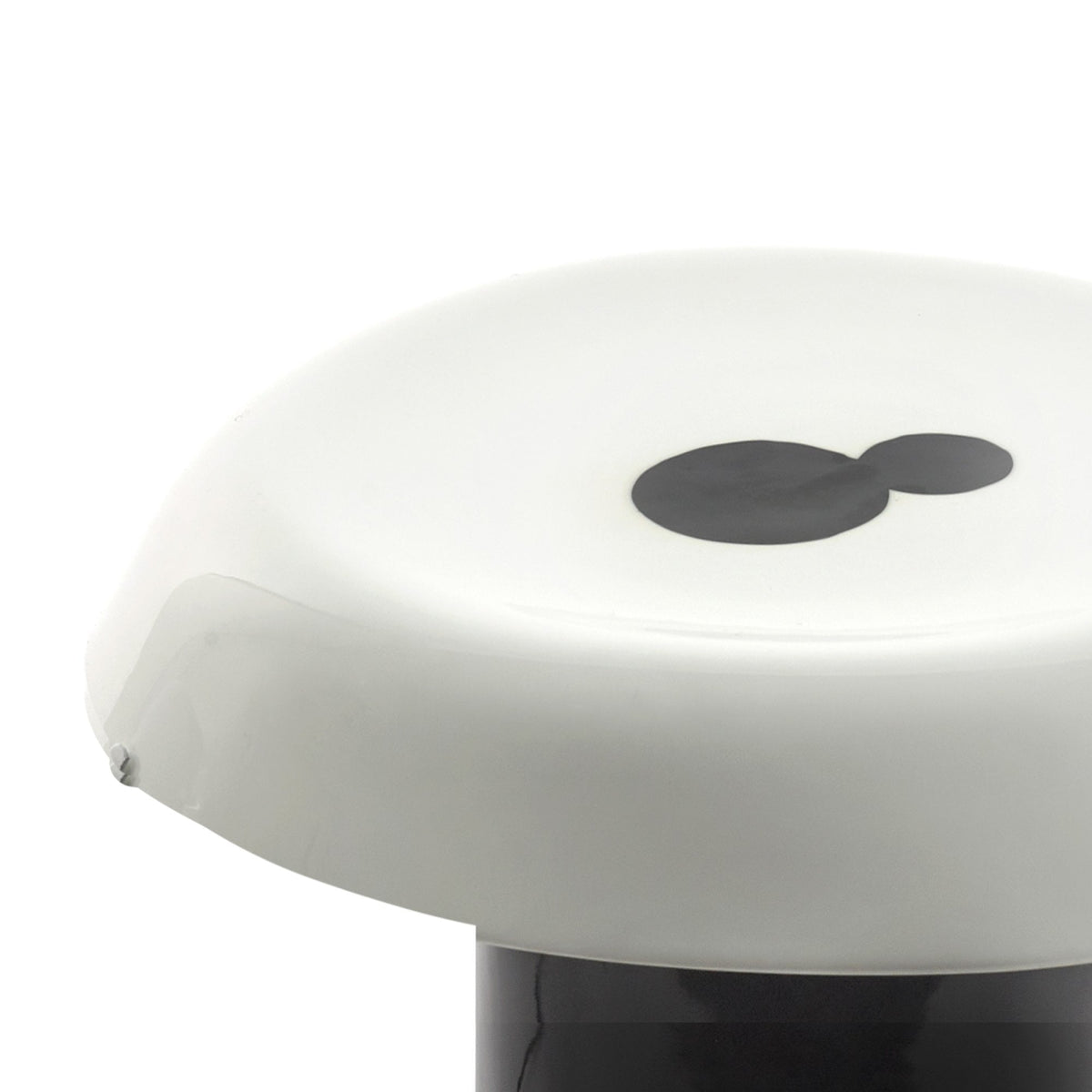 A close-up of the white, opaque shade of a modern mushroom-shaped lamp.