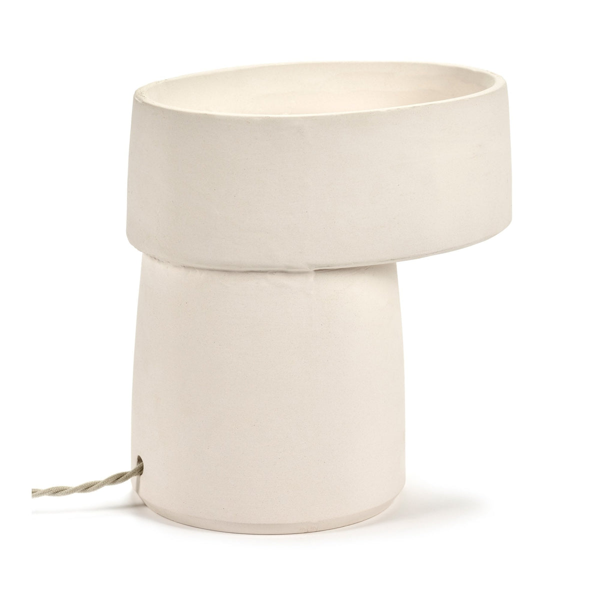A white ceramic table lamp with an oval top and a visible fabric-covered power cord.