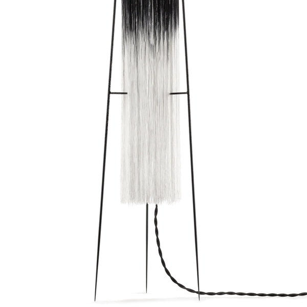 A close-up of the lamp's white shade and braided power cord.