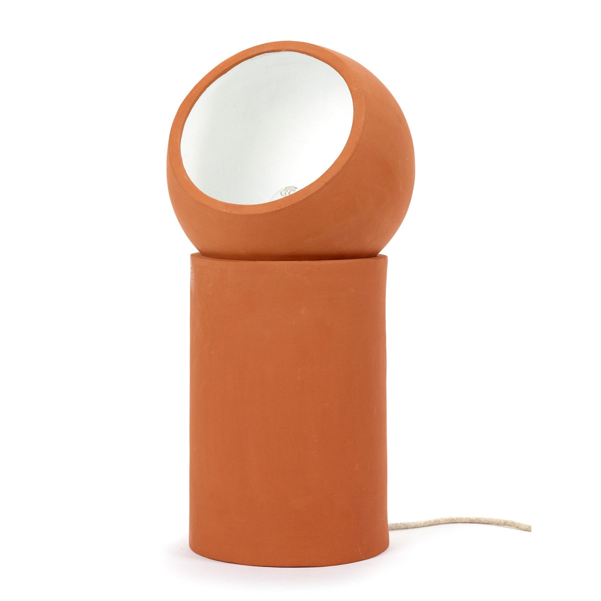 A minimalist terracotta table lamp, cylindrical base with a spherical, angled shade, on a white background.